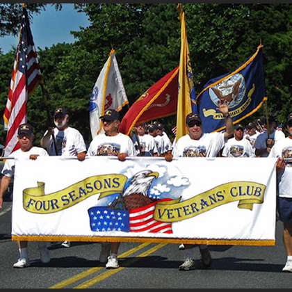 a group of men holding a banner that says four seasons veterans club
